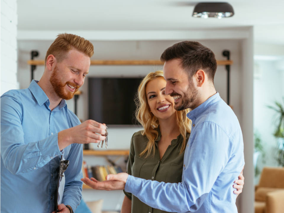 realtor handing keys to new homeowners